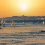 Traditional feluccas sailing on the River Nile at sunset