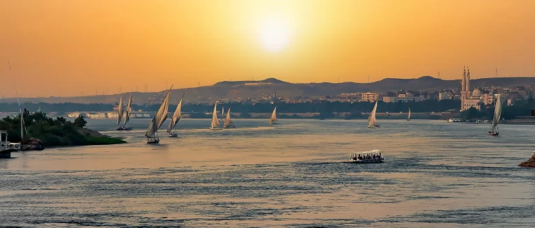 Traditional feluccas sailing on the River Nile at sunset