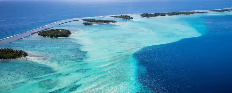 Aerial view of a turquoise lagoon and coral reef in French Polynesia