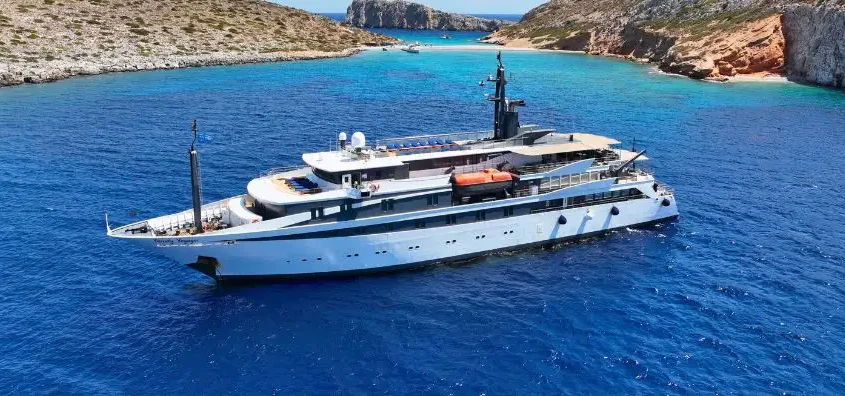 A luxury small cruise ship (Voyager) sailing through clear blue waters, offering boutique voyages.