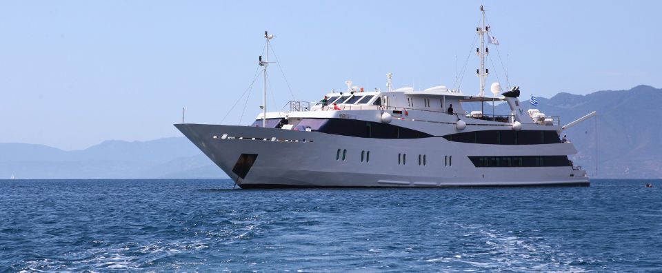 A small cruise ship sailing through the Greek islands under clear blue skies. A small cruise ship sailing through the Greek islands under clear blue skies.