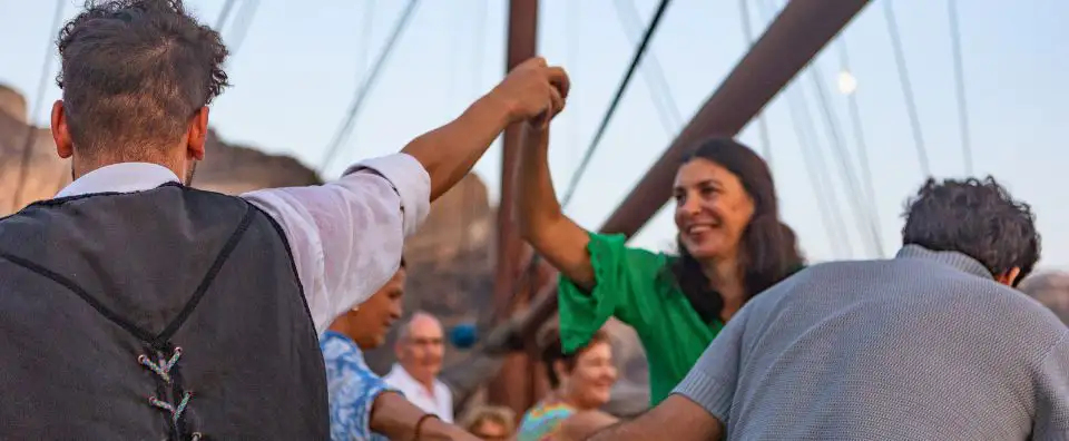 Guests enjoying a lively evening on a small cruise ship deck, embracing the onboard atmosphere Guests enjoying a lively evening on a small cruise ship deck, embracing the onboard atmosphere