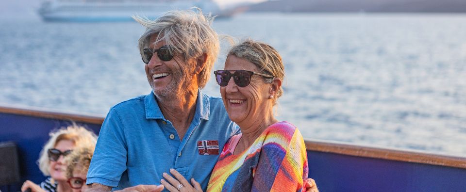 Smiling couple enjoying a small cruise ship journey in Greece with the sea in the background. Smiling couple enjoying a small cruise ship journey in Greece with the sea in the background.
