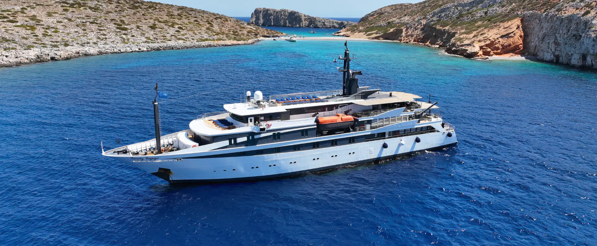 A small ship cruise sailing near a secluded island, offering eco-friendly and sustainable travel experiences