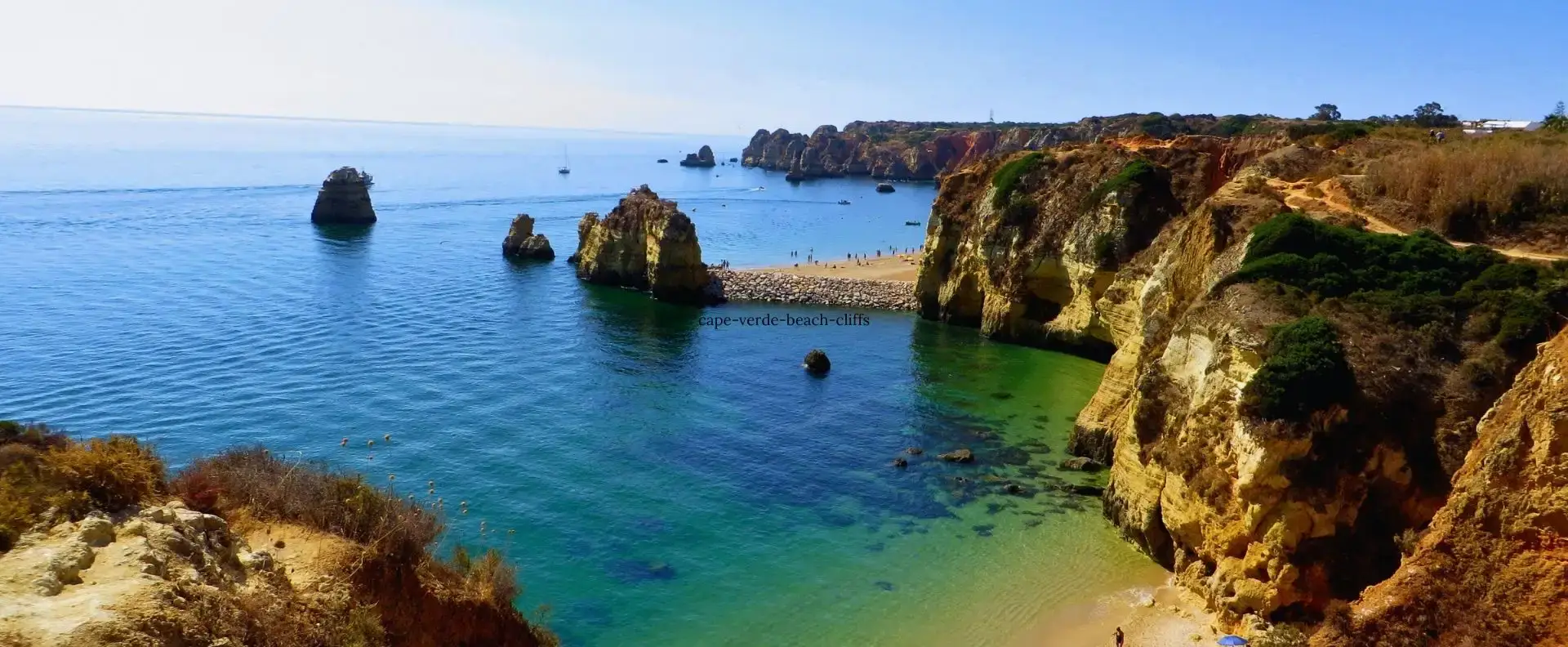 Scenic beach and cliffs seen from a Cape Verde cruise, with turquoise waters and golden sands