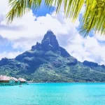 Overwater bungalows and Mount Otemanu in Bora Bora, a scenic highlight of small ship cruising in Tahiti.