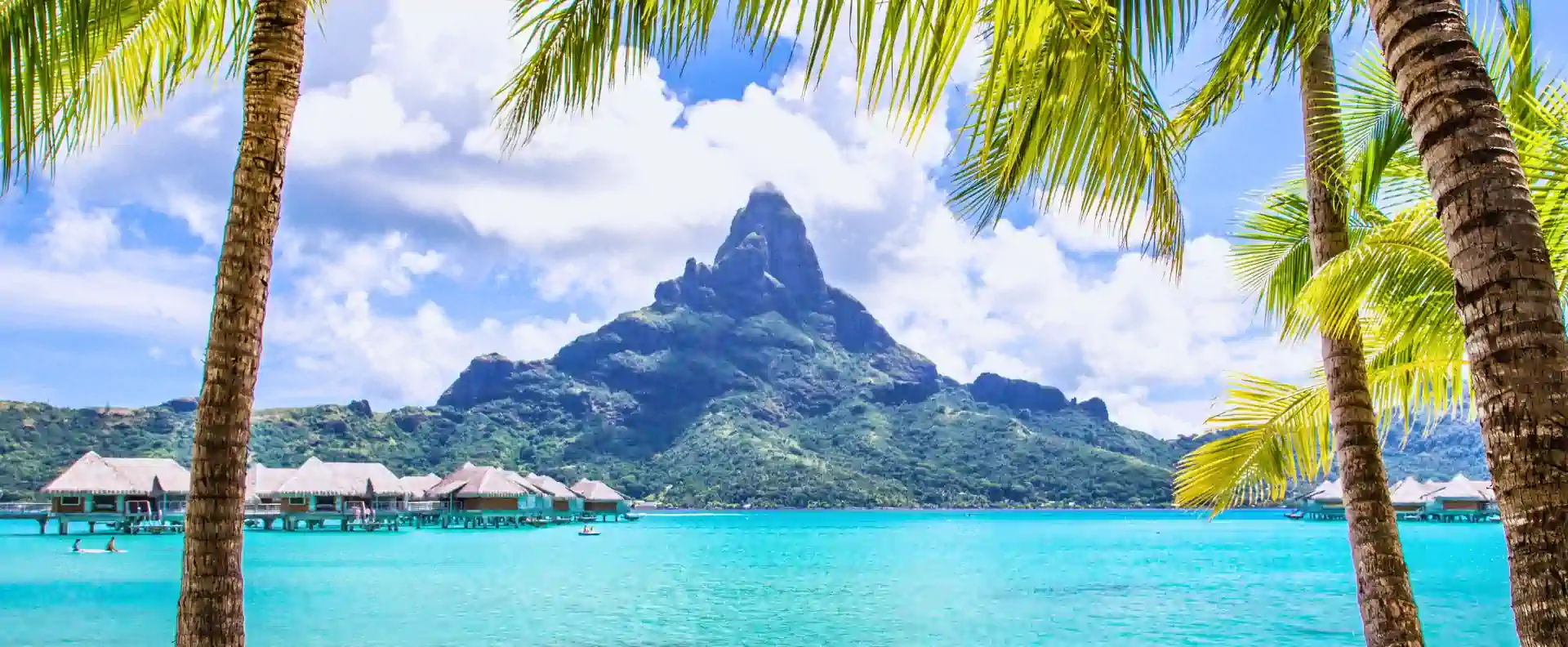 Overwater bungalows and Mount Otemanu in Bora Bora, a scenic highlight of small ship cruising in Tahiti.