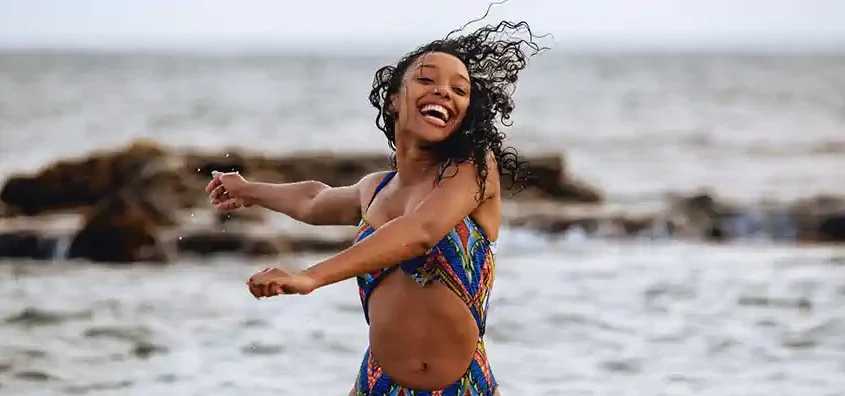 Smiling woman enjoying the beach in Cape Verde, representing local culture and joy