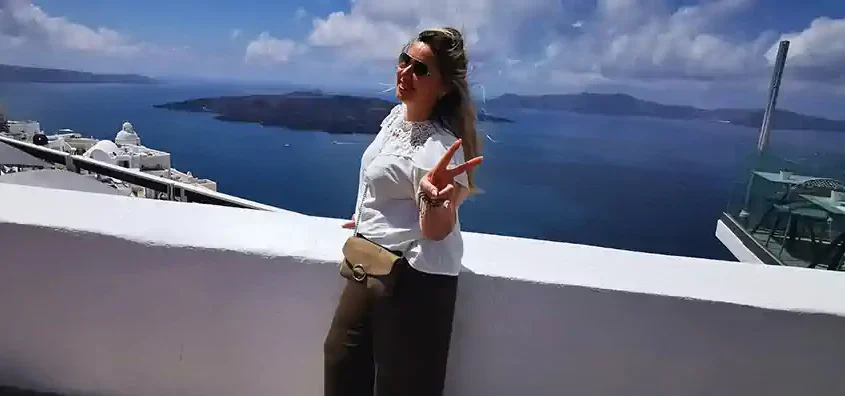 Cristiana enjoying the view in Santorini during a reflective moment on a small ship cruise in Greece