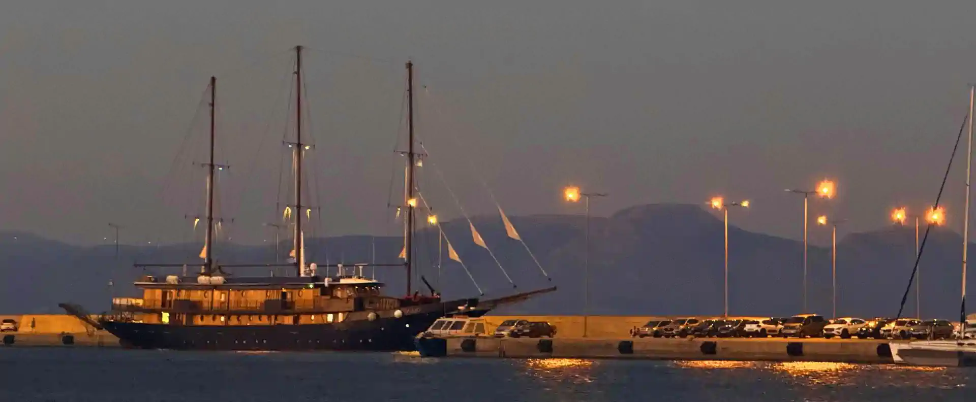 MS Galileo moored at a Peloponnese harbour at dusk with masts lit on a Greek coastal cruise.