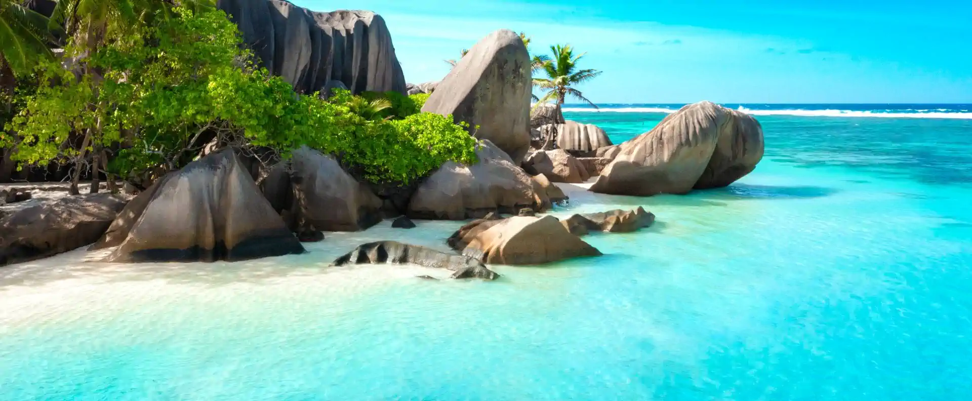 Turquoise lagoon and granite coves seen on a small-ship stop during Seychelles island hopping.