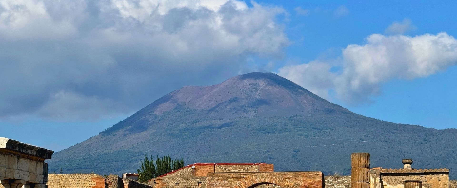 Mount Vesuvius rising behind Pompeii ruins on an Aeolian Islands Cruise itinerary from Naples.