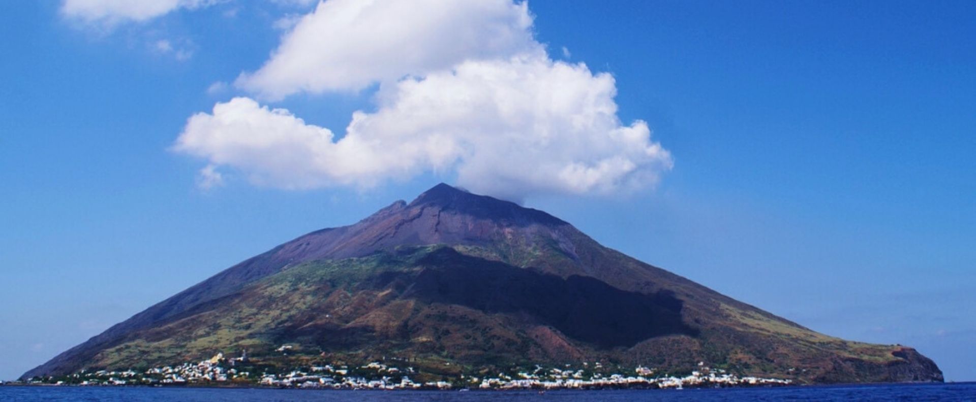 Stromboli volcano rising above the Aeolian Islands on an Aeolian Islands Cruise, seen from the sea.