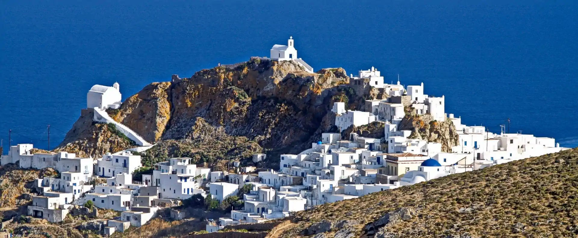Greek island cruises to Chora in Serifos, with whitewashed houses and hilltop churches overlooking the Aegean.