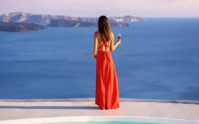 greece cruise destination santorini sea view Greece cruise destination with a woman overlooking the Santorini caldera and Aegean Sea at sunset