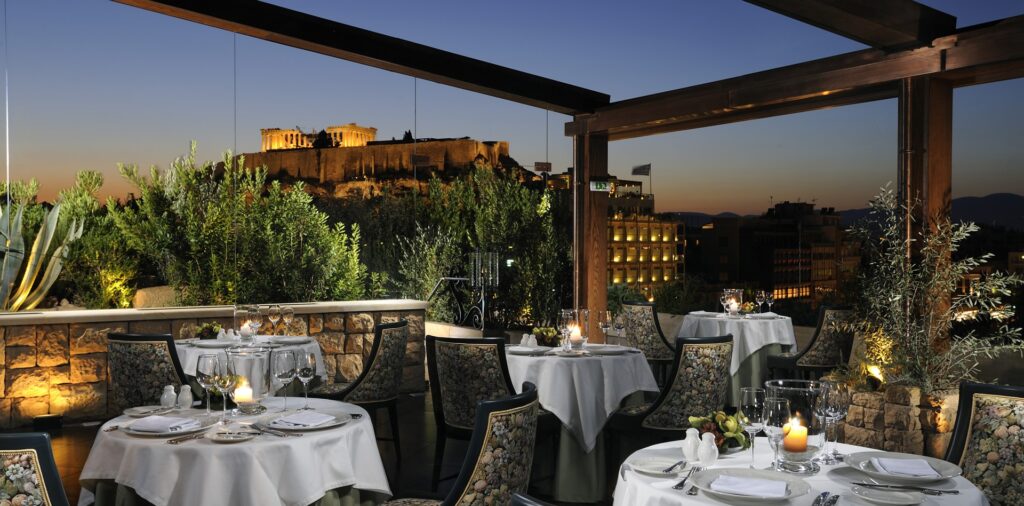 Hotel roof terrace at night with the Acropolis lit up behind